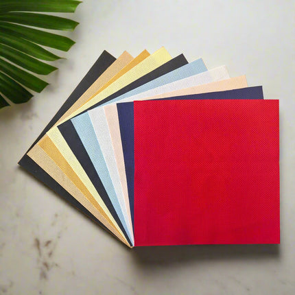 Set of colorful cross stitch fabric sheets on a white background