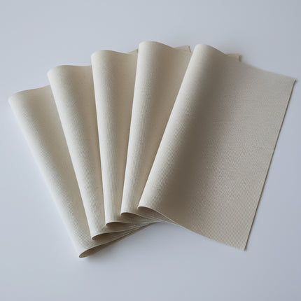 Set of four beige placemats on a white background