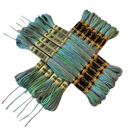 Set of embroidery threads in green and blue shades on a beige background