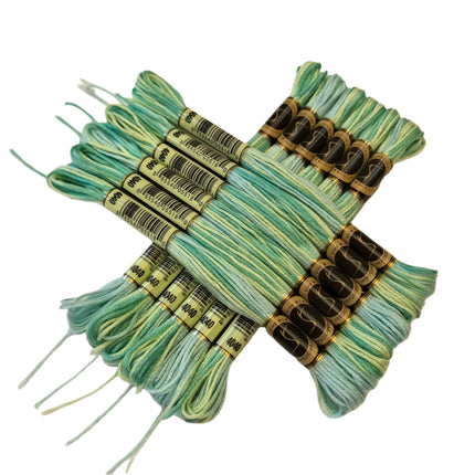 Set of green and blue embroidery floss bundles on a beige background