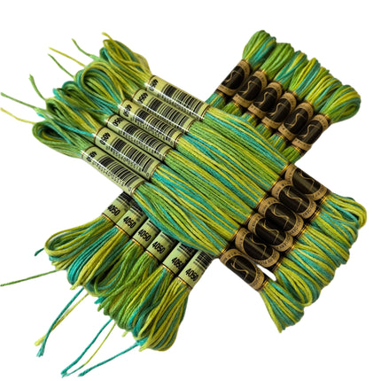 Bundles of green embroidery floss with labels on a light background