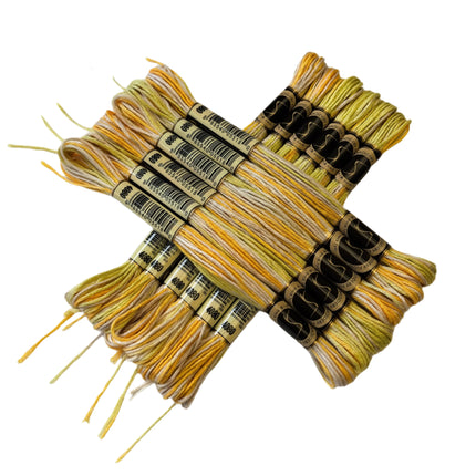 Set of yellow and black embroidery threads with labels on a light fabric background