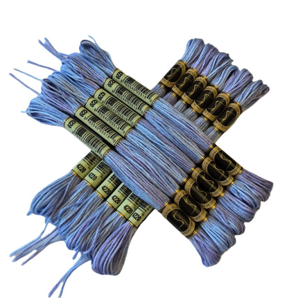 Set of light blue embroidery threads with labels on a beige background