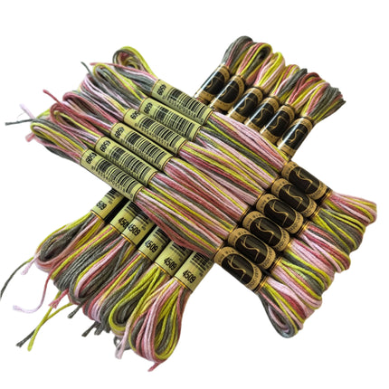 Set of colorful embroidery floss bundles on a light fabric background