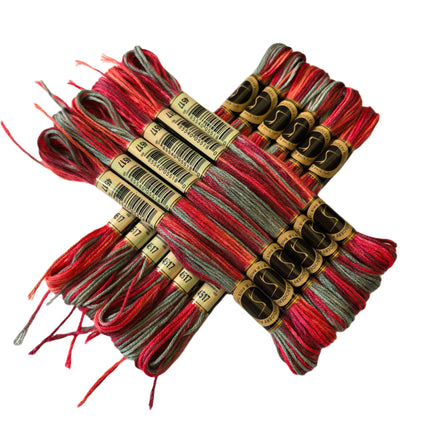 Set of red and gray embroidery threads with labels on a beige fabric background